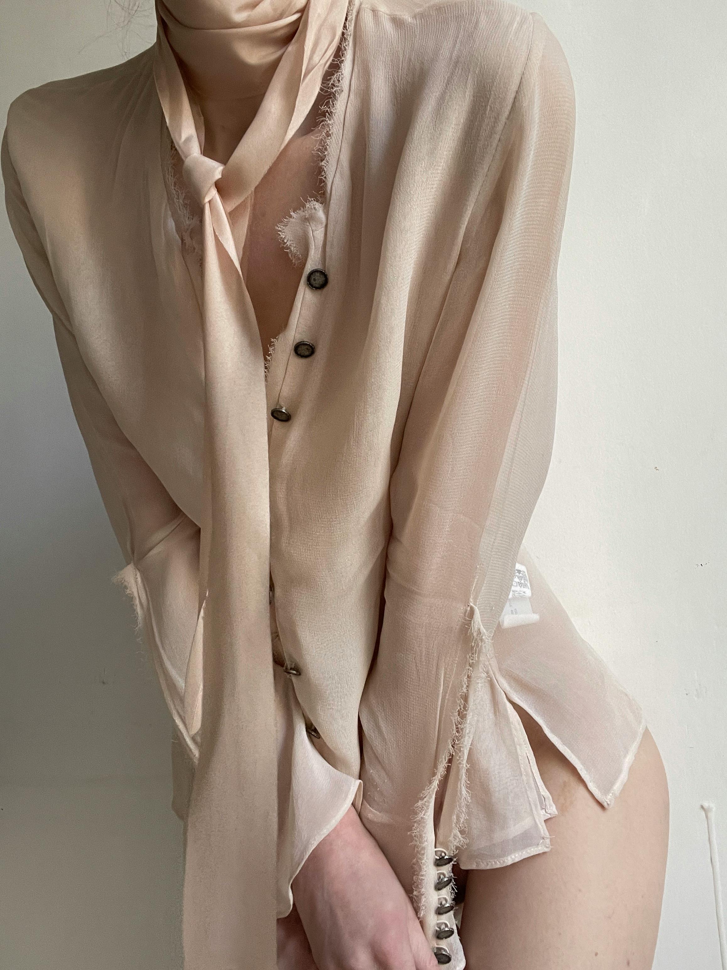 Mannequin wearing a sheer beige outfit with buttons against a white background