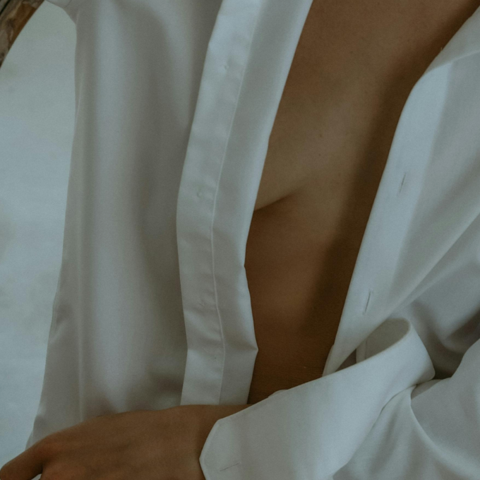 Close-up of a person wearing a white shirt with a blurred background