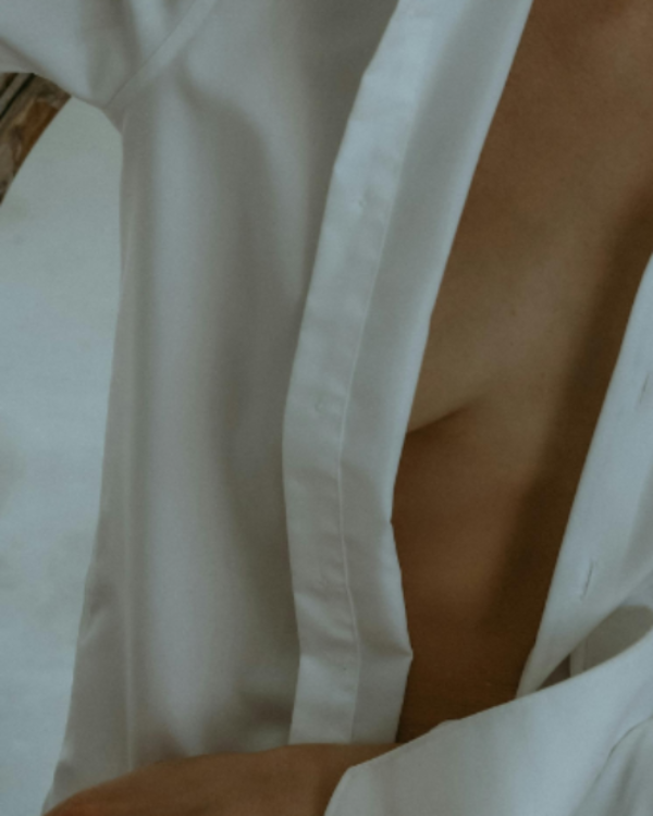 Close-up of a person wearing a white shirt with a blurred background